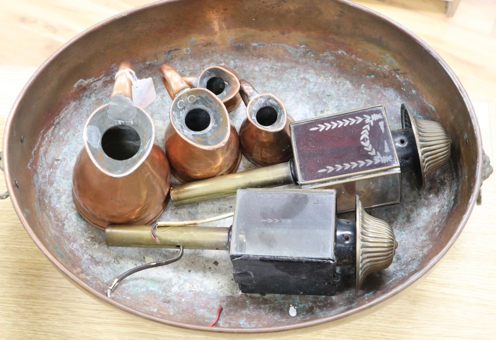 Four copper graduated jugs and a pair of red glass and brass coaching lamps and a copper two-handled planter